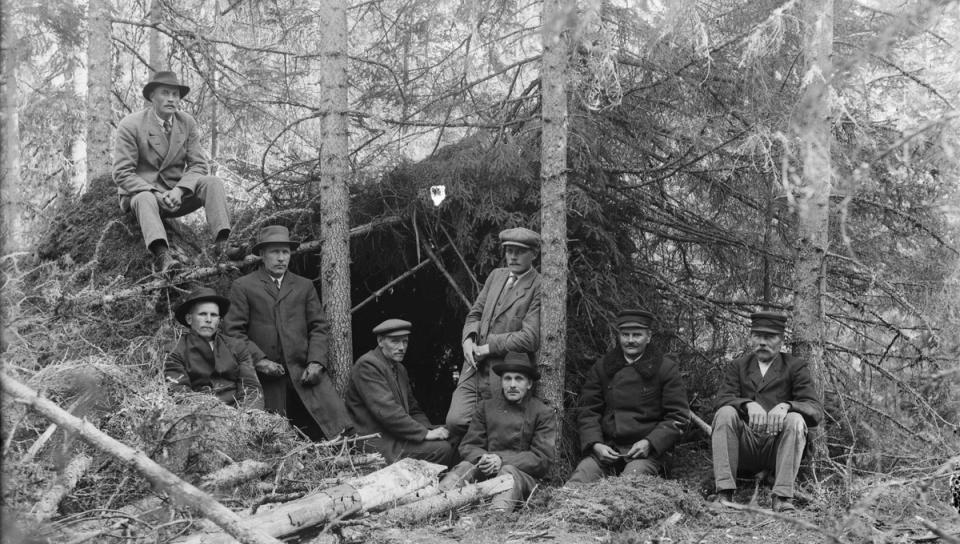 ihmisiä vartiossa metsässä
