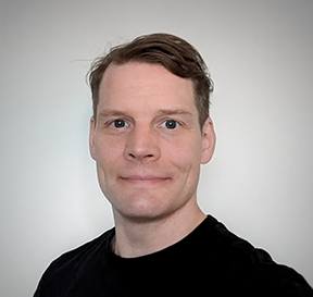 potrettikuva mieshenkilöstä jolla on lyhyet vaaleanruskeat, sivulle kammatut hiukset